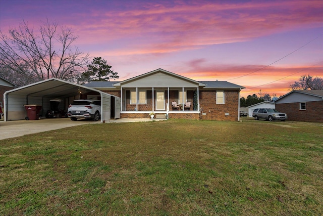  - ranch-style house featuring brick siding, a detached carport, driveway, and a front lawn