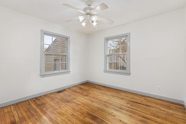 empty room with hardwood / wood-style floors and ceiling fan