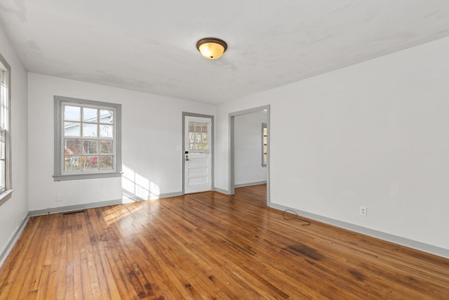 unfurnished room featuring hardwood / wood-style floors and plenty of natural light