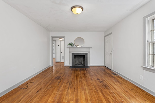 unfurnished living room with hardwood / wood-style floors and a fireplace