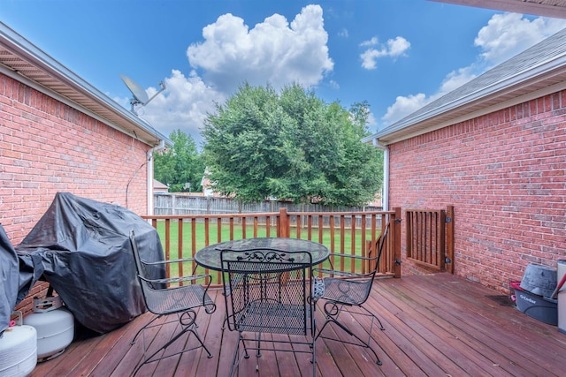  - wooden terrace featuring a fenced backyard, outdoor dining space, and grilling area