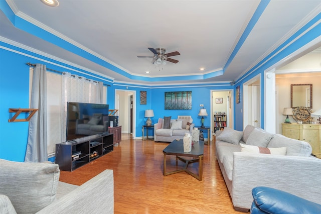  - living room with a ceiling fan, ornamental molding, a tray ceiling, light wood-style floors, and recessed lighting