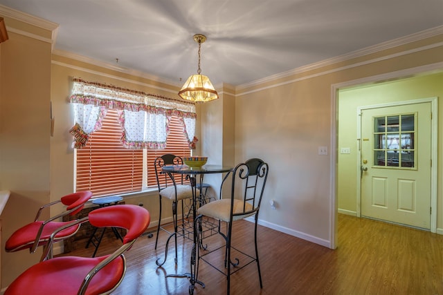  - dining room featuring wood finished floors, ornamental molding, and a chandelier