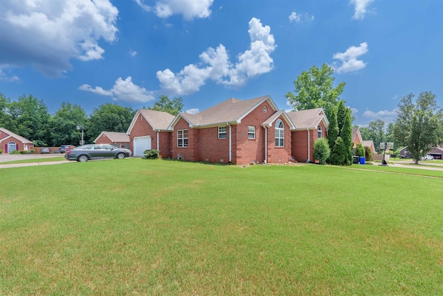  - view of front of house with an attached garage, brick siding, a front yard, and driveway