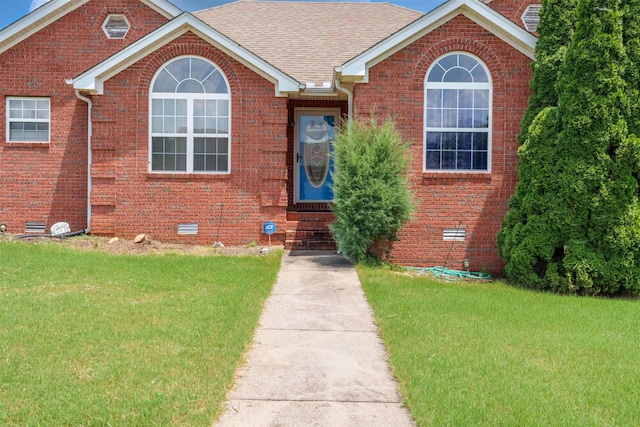  - view of front of home with a front lawn, crawl space, and brick siding