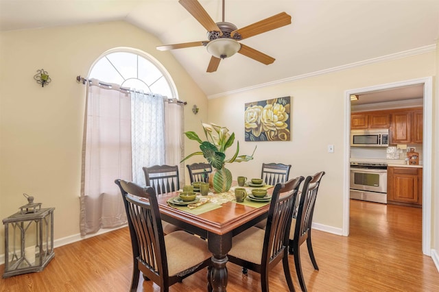  - dining room featuring ceiling fan, light wood-type flooring, vaulted ceiling, and crown molding