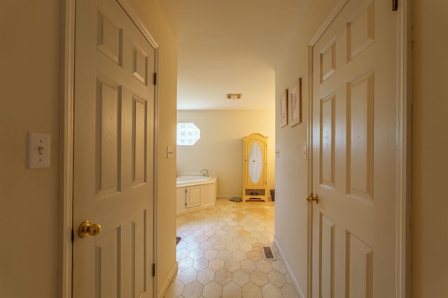  - hall featuring light tile patterned flooring and baseboards
