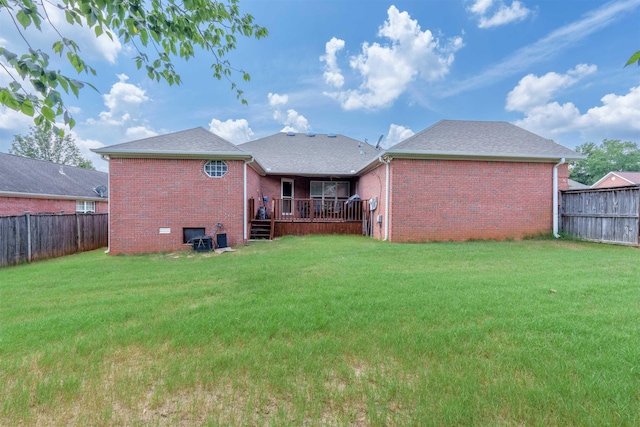  - back of house featuring brick siding, a fenced backyard, and roof with shingles