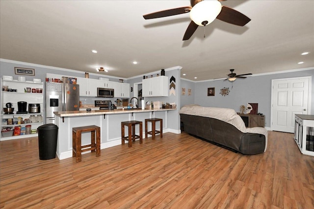 bedroom with stainless steel fridge, light wood-type flooring, ornamental molding, and sink