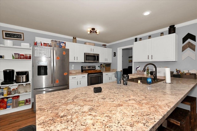 kitchen featuring ornamental molding, a breakfast bar, stainless steel appliances, sink, and white cabinetry