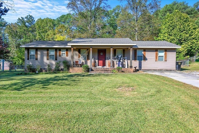 ranch-style home featuring a front yard, covered porch, and driveway