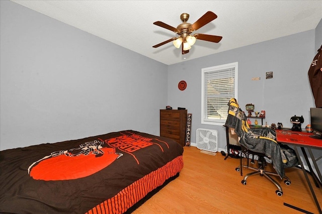 bedroom with ceiling fan, light hardwood / wood-style flooring, and a textured ceiling