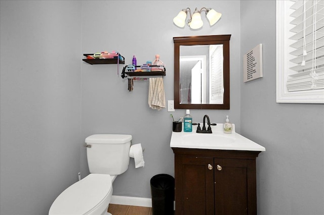 bathroom with vanity, toilet, and baseboards