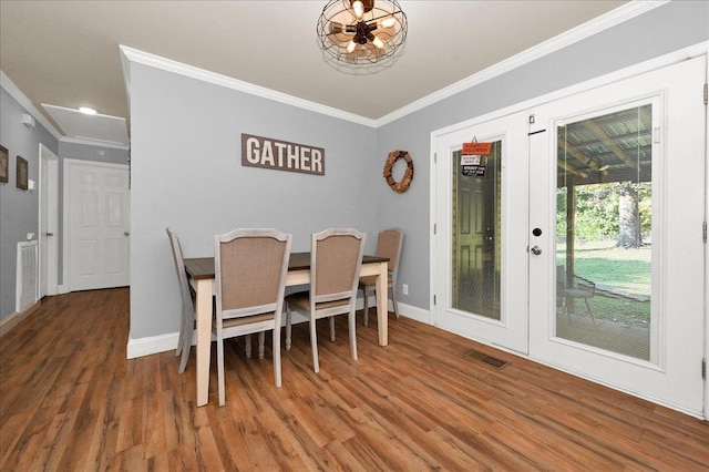 dining room with dark hardwood / wood-style flooring, a notable chandelier, and ornamental molding