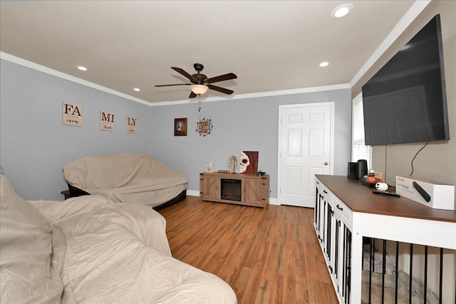 living room featuring a ceiling fan, recessed lighting, crown molding, light wood finished floors, and baseboards