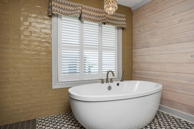 bathroom with tile patterned floors, a bathing tub, wooden walls, and a chandelier