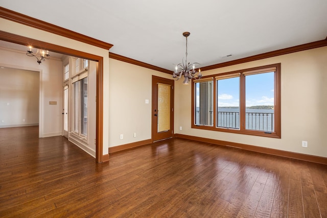 empty room with dark wood-type flooring, a chandelier, and ornamental molding