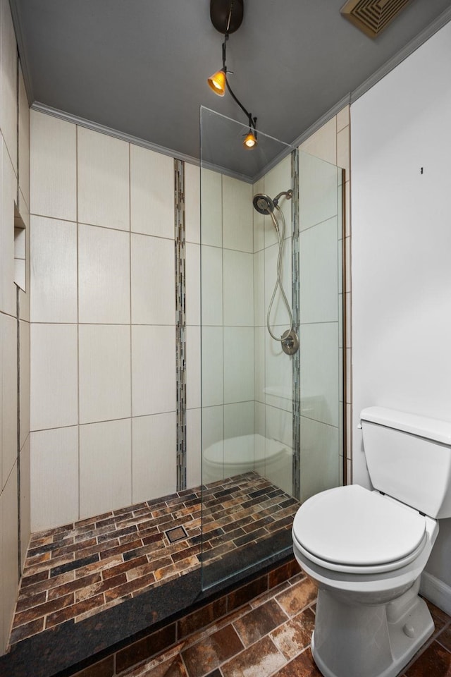 bathroom with toilet and a tile shower