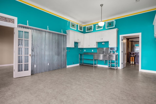 kitchen with pendant lighting, white cabinetry, and ornamental molding