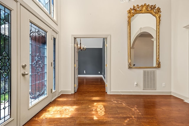 foyer entrance with hardwood / wood-style floors and a chandelier