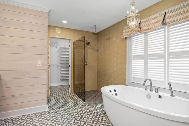 bathroom with plus walk in shower, an inviting chandelier, and wooden walls