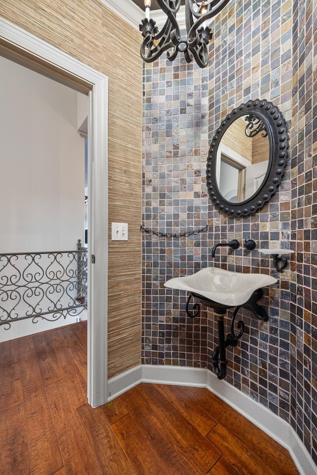 bathroom with a chandelier and hardwood / wood-style floors