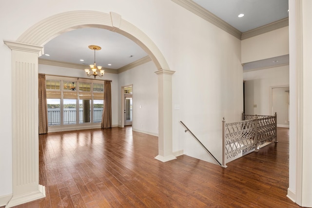 interior space featuring crown molding, dark wood-type flooring, and an inviting chandelier