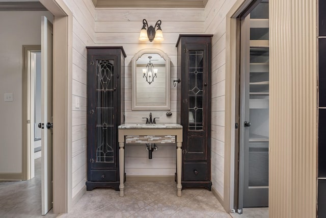 bathroom featuring wood walls and sink