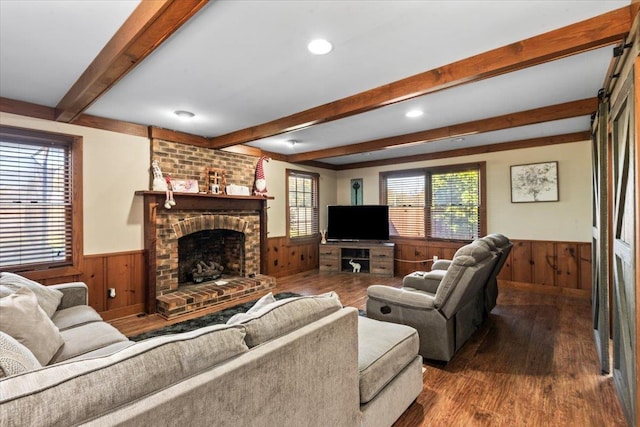 living room featuring hardwood / wood-style floors, a fireplace, and beamed ceiling