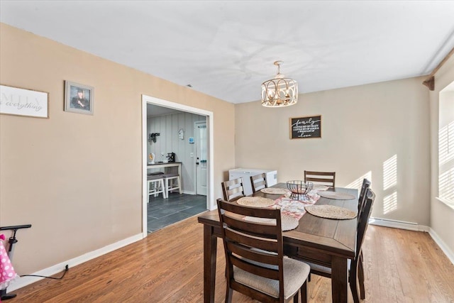 dining room with hardwood / wood-style flooring and a notable chandelier