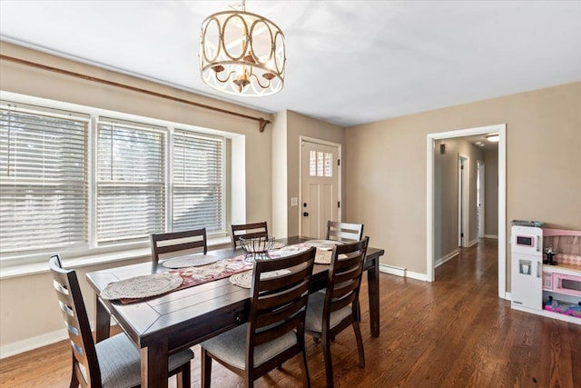 dining room with dark hardwood / wood-style floors and an inviting chandelier