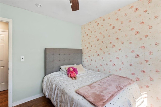 bedroom with dark hardwood / wood-style flooring and ceiling fan