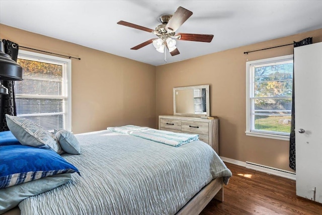 bedroom featuring ceiling fan, dark wood-type flooring, and a baseboard heating unit