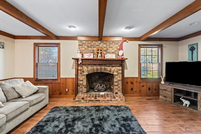 living room with a brick fireplace and hardwood / wood-style flooring