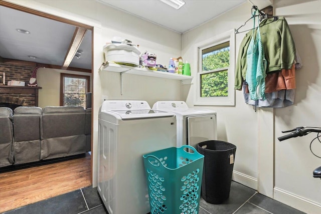 laundry area featuring a fireplace, washing machine and dryer, and dark tile patterned flooring