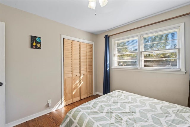 bedroom with ceiling fan, a closet, and wood-type flooring