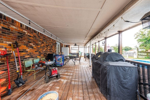 deck with a fenced in pool and grilling area