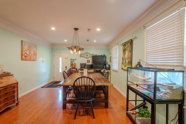 dining room featuring crown molding, light hardwood / wood-style flooring, and a healthy amount of sunlight