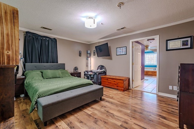 bedroom featuring light wood-type flooring, a textured ceiling, and ornamental molding