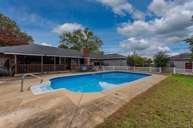 view of pool with a lawn and a patio area