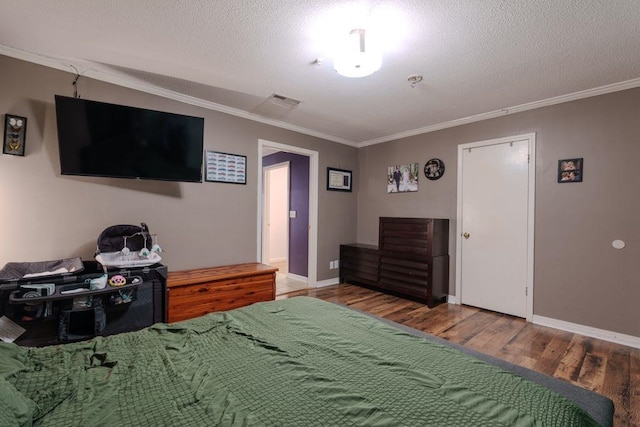 bedroom featuring wood-type flooring, a textured ceiling, and ornamental molding