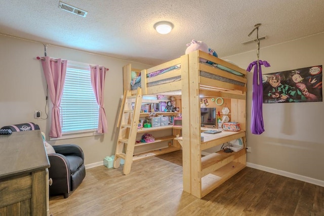 bedroom featuring wood-type flooring and a textured ceiling