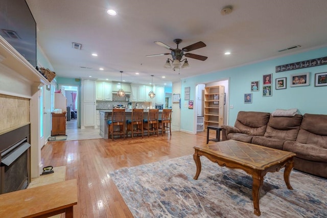 living room with light wood-type flooring and ceiling fan