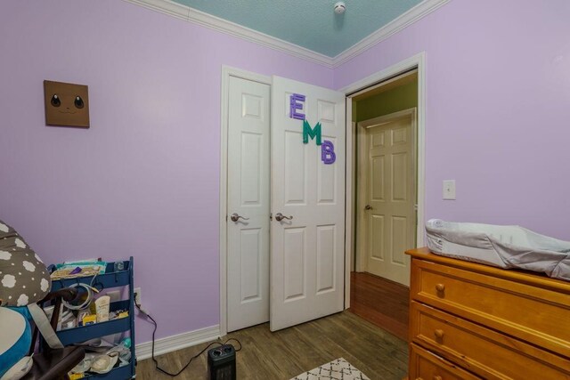 bedroom featuring ornamental molding, a closet, and dark wood-type flooring