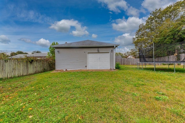 garage featuring a lawn and a trampoline