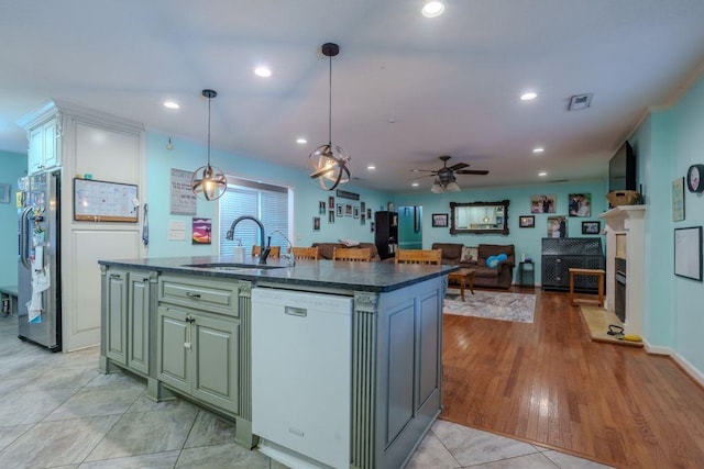 kitchen with ceiling fan, sink, decorative light fixtures, a center island with sink, and dishwasher