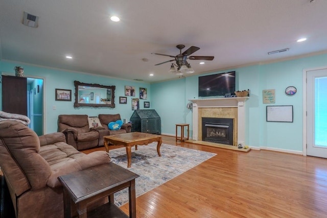 living room with hardwood / wood-style floors, ceiling fan, and crown molding