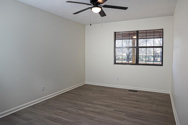 unfurnished room featuring visible vents, ceiling fan, baseboards, a textured ceiling, and dark wood-style flooring