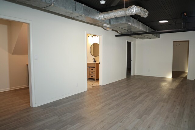 interior space featuring wood finished floors, baseboards, and a sink