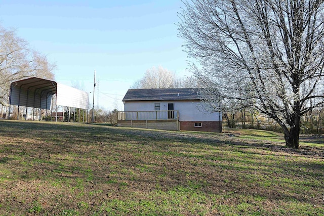 view of yard featuring a detached carport and a wooden deck